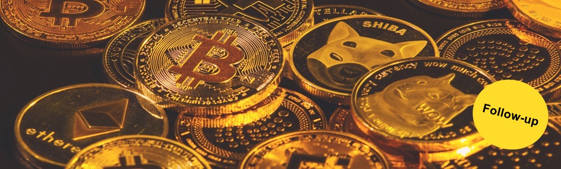 Goldene Münzen mit verschiedenen Kryptowährungen darauf abgebildet auf schwarzem Untergrund.