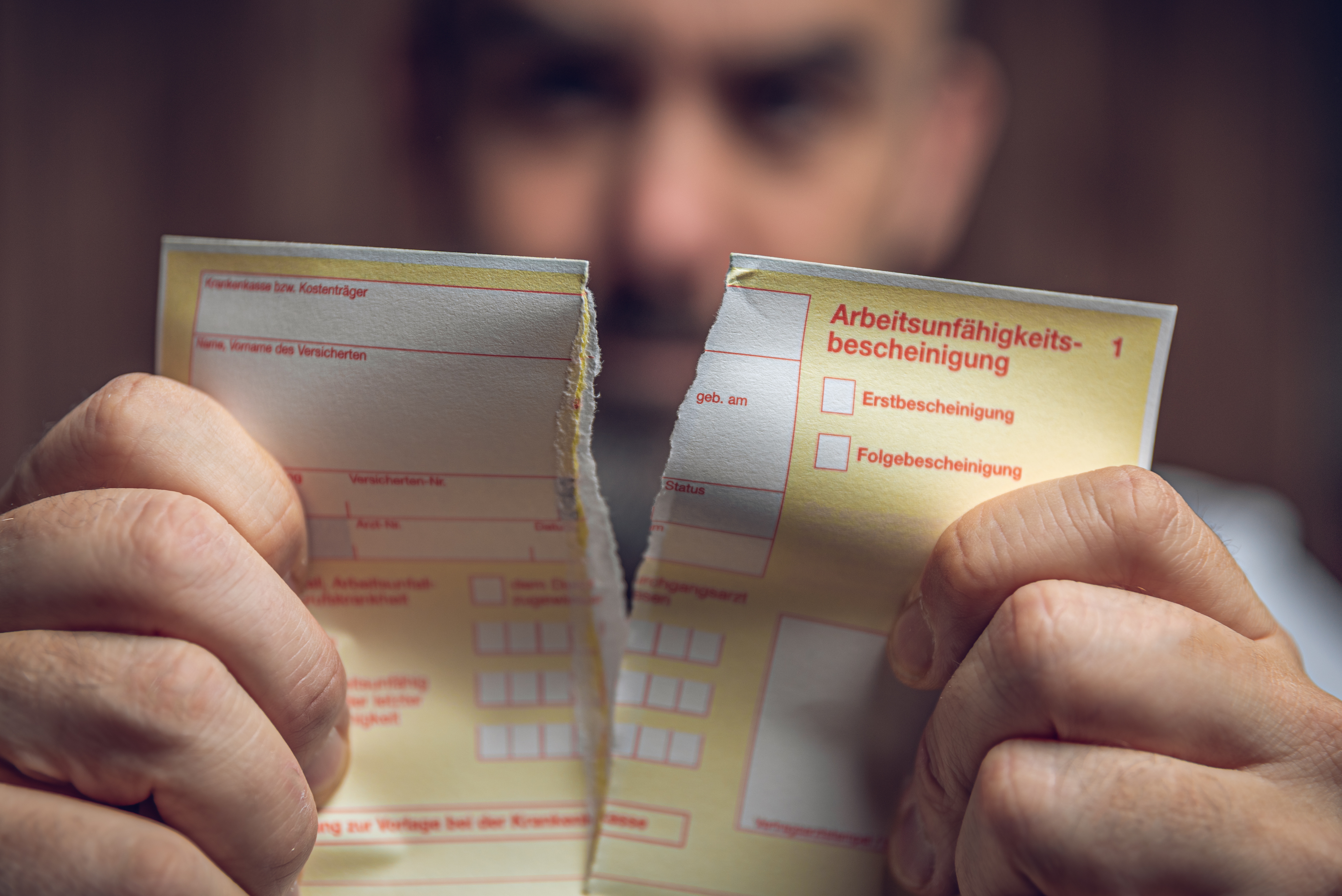 Photo: a man tears up a certificate of incapacity for work