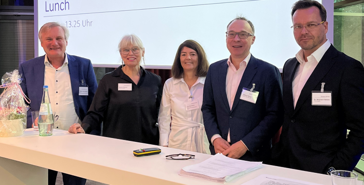 Image: five Baker Tilly-experts are standing in front of a screen at the R&W “Global Minimum Tax” conferenc