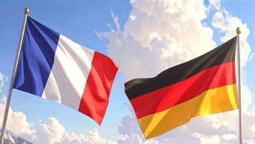 Man sieht ein Bild, auf der eine französische und eine deutsche Nationalflagge im Wind vor einem strahlenden Himmel mit idyllischen weißen Wolken wehen.