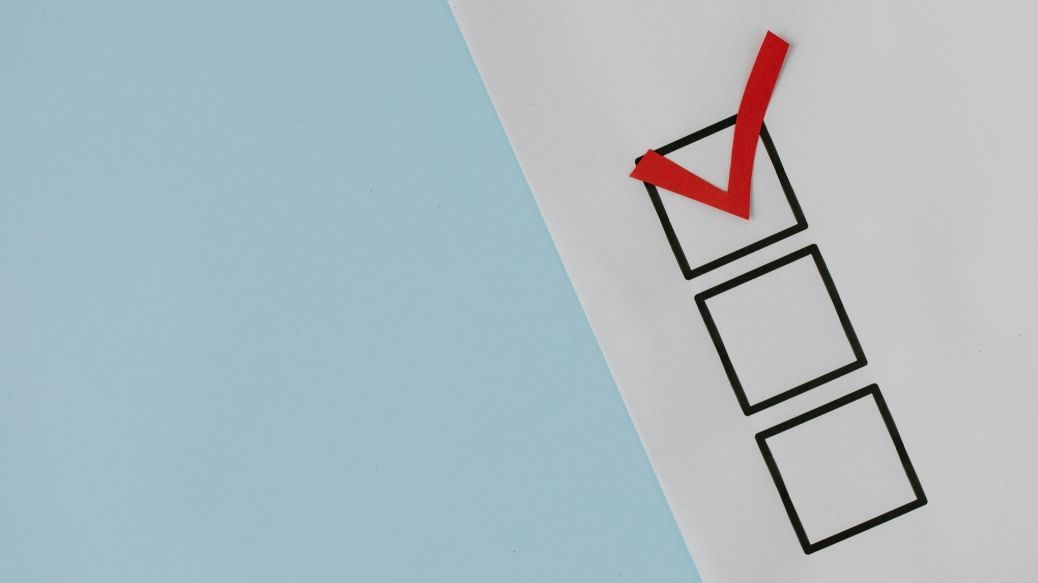 Foto: Ein Wahlzettel vor hellblauem Grund.