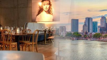 Blick in das Restaurant CRESCO verschwimmt mit der morgendlichen Skyline von Frankfurt am Main