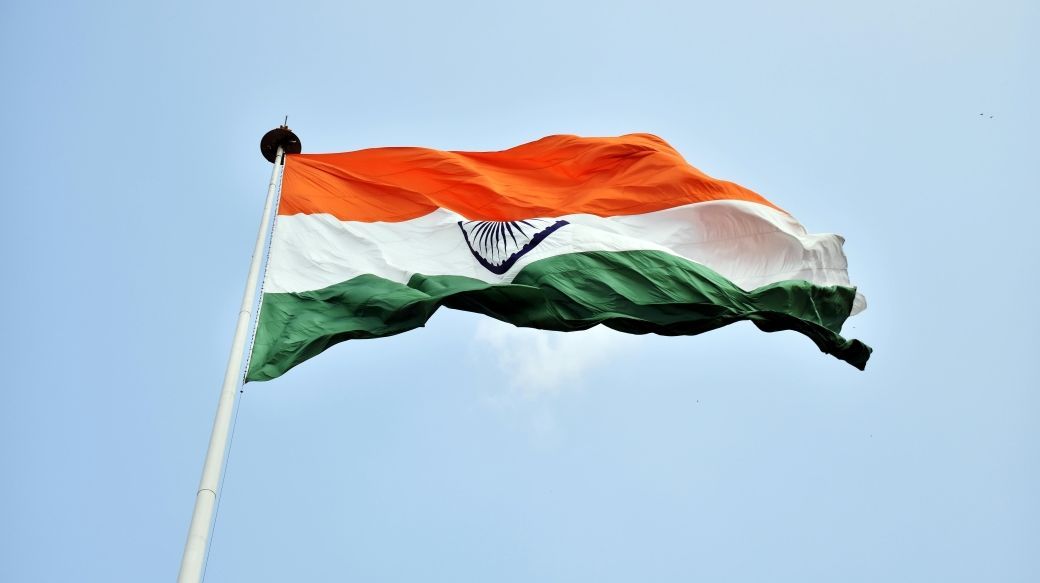 Foto: Wehende indische Flagge vor blauem Himmel.