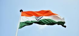 Foto: Wehende indische Flagge vor blauem Himmel.