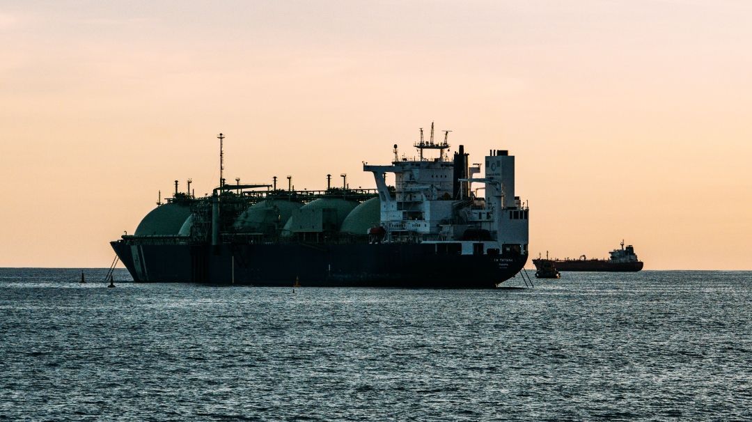 Foto: Ein LNG-Tanker fährt bei Sonnenaufgang auf ruhiger See.