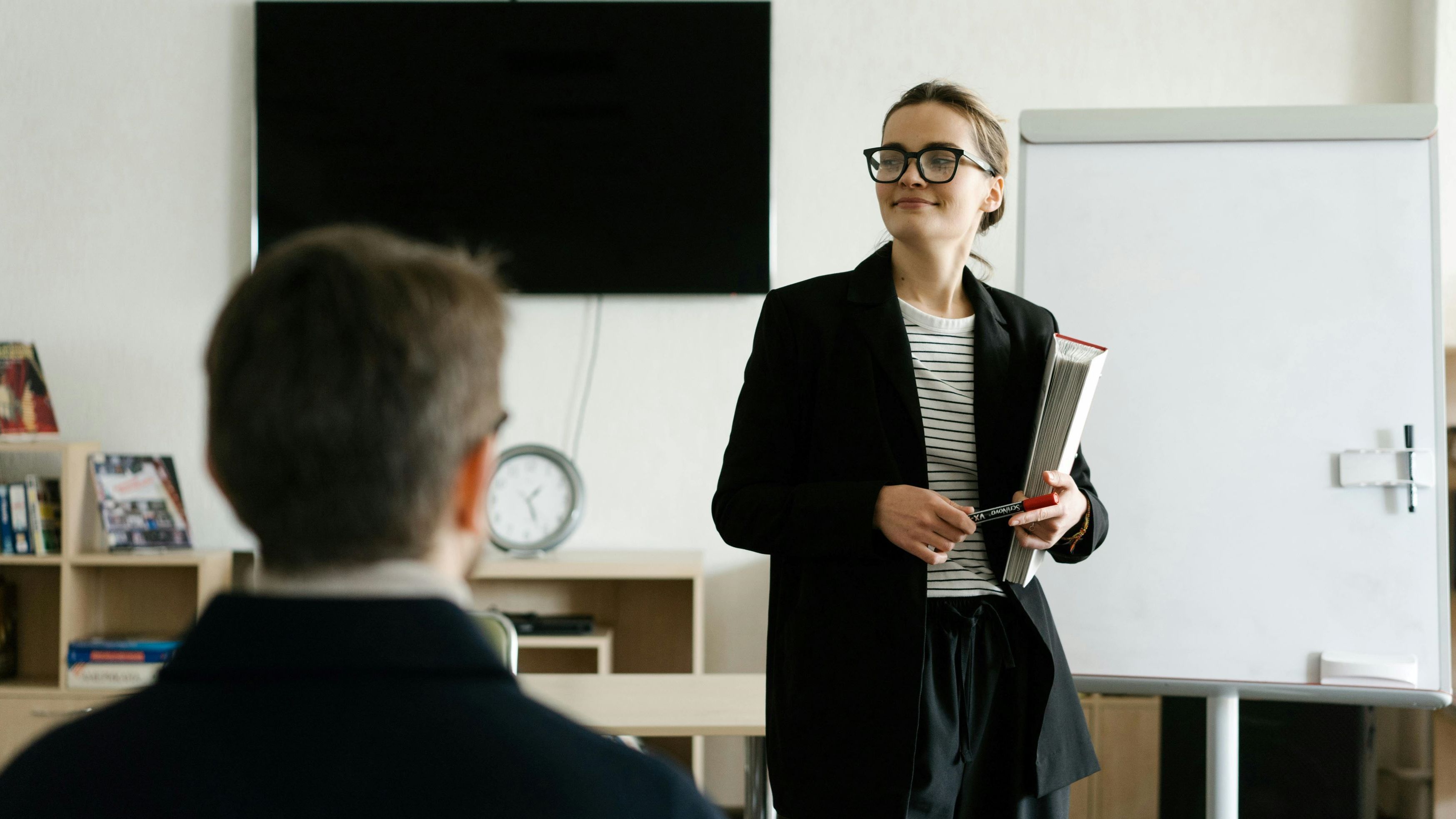Image: Woman standing in the office and giving a lecture