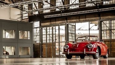 Blick in eine große Halle, in der sich mehrere elegante Autos befinden.