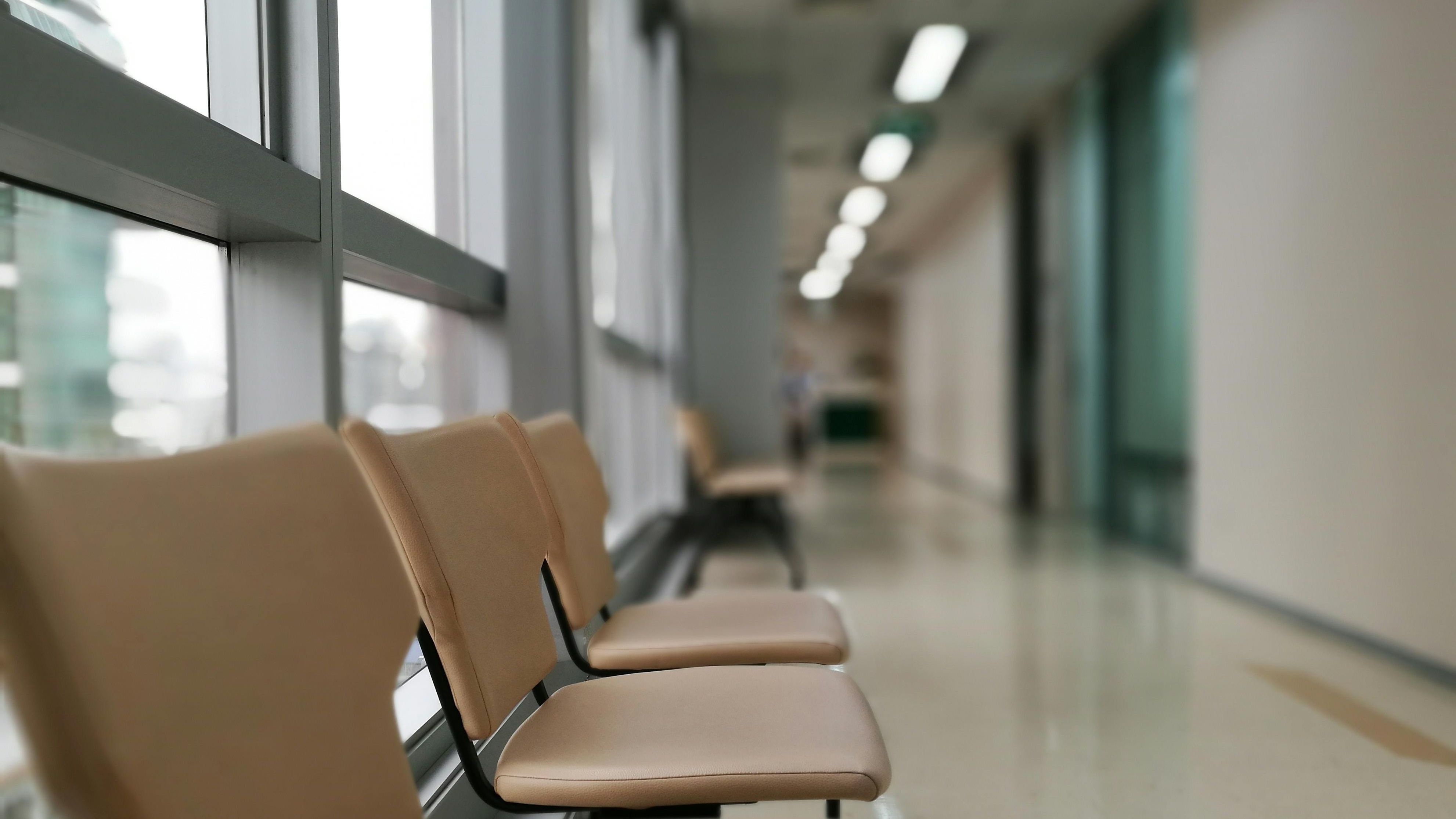 Foto: Leerer Krankenhausflug, im Vordergrund eine Sitzbank mit beigefarbenen Lederbezügen.