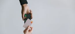 Foto: Eine Bankkarte wird an ein Kartenlesegerät gehalten.