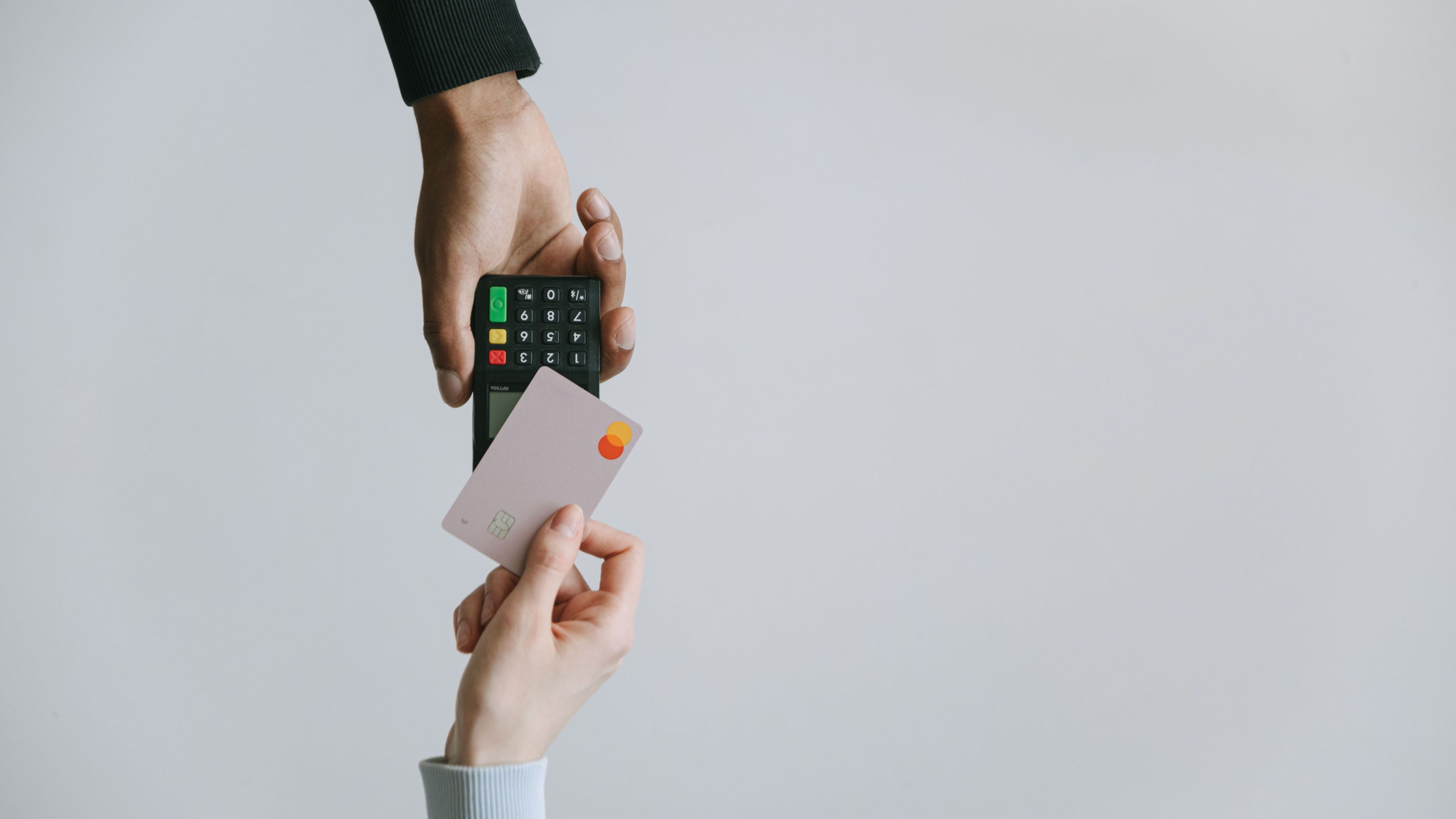 Foto: Eine Bankkarte wird an ein Kartenlesegerät gehalten.